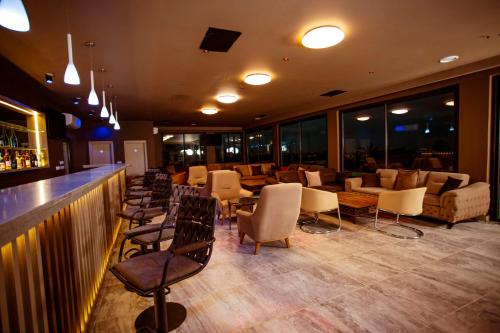 a restaurant with a bar with chairs and tables at Hôtel les Vallons in Abidjan