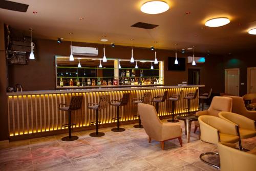 a bar in a restaurant with chairs and a counter at Hôtel les Vallons in Abidjan