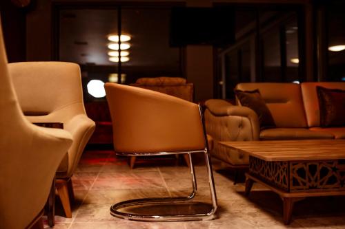 a room with a chair and a table and couches at Hôtel les Vallons in Abidjan