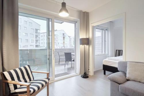um quarto com uma cama, uma cadeira e uma janela em Norden Homes Castle Harbour Apartment em Turku