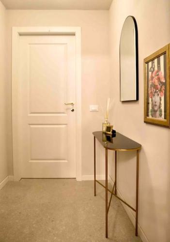 a hallway with a door and a table and a mirror at La casa in Carteria in Modena