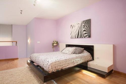 een slaapkamer met een bed en een schilderij aan de muur bij Vale Beach in Barcelona