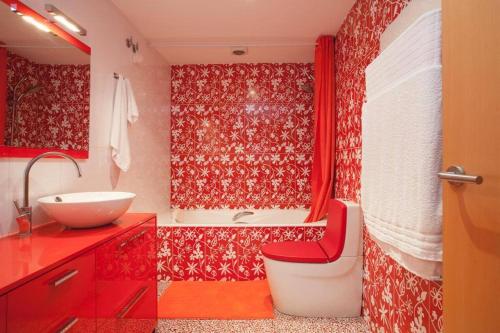 a bathroom with a red shower curtain and a sink at Vale Beach in Barcelona