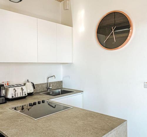 a kitchen with a sink and a clock on the wall at Valletta Vista Penthouse Where Sky Meets History By Solea in Sliema