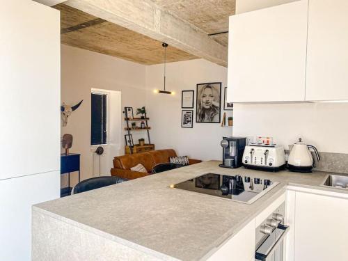 a kitchen with a counter top and a living room at Valletta Vista Penthouse Where Sky Meets History By Solea in Sliema