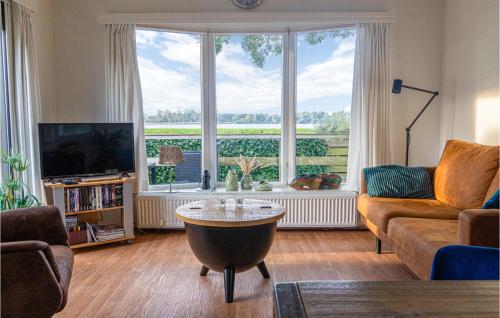 a living room with a couch and a large window at 2 Bedroom Gorgeous Home In Lauwersoog in Lauwersoog