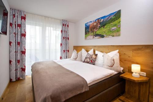 een slaapkamer met een bed met een koe aan de muur bij 5 Sterne FeWo Allgäuer Alm mit Schwimmbad und Sauna in Oberstaufen