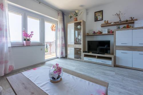 a living room with white cabinets and a tv at Apartments Melita in Dramalj