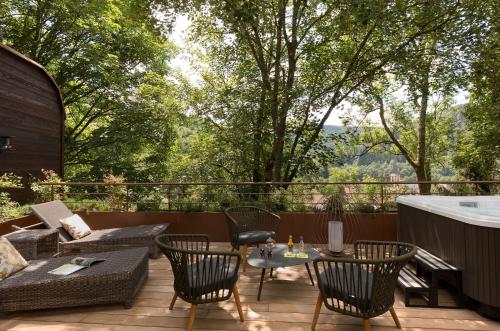a patio with a table and chairs and a bath tub at LA CHENEAUDIÈRE - Hôtel Spa - Relais & Châteaux - Restaurant étoilé in Colroy-la-Roche