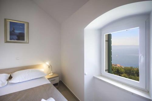 ein Schlafzimmer mit einem Bett und einem großen Fenster in der Unterkunft Holiday Home Aria in Podgora