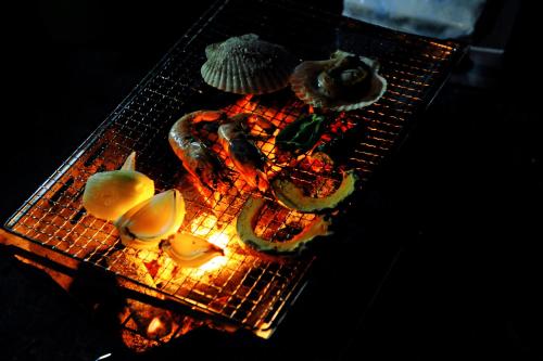 a grill with meat and vegetables on top of it at Otarunishikien in Otaru