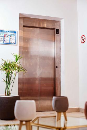 a metal elevator in a room with two chairs at Hôtel les Vallons in Abidjan