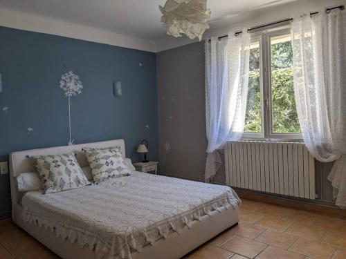 a bedroom with a large bed with blue walls at Mas dans les lavandes in Ménerbes