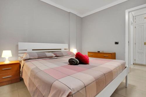 a bedroom with a bed with a red pillow on it at Halcon - Costa del Silencio in Costa Del Silencio