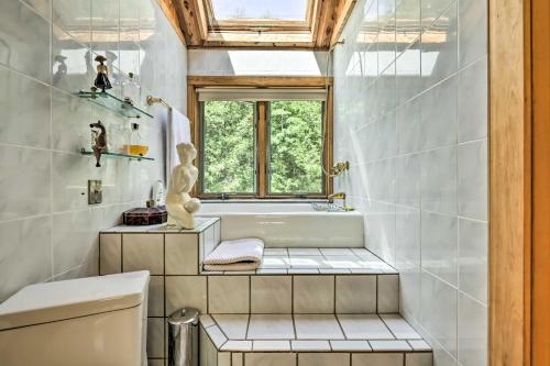 a bathroom with a tub and a sink and a window at Modern Catskills Escape on 25 Acres with Deck! in Mountain Dale
