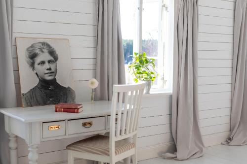 a room with a desk and a picture of a woman at Bergs Gård & Hållsvikens Gård in Västerljung