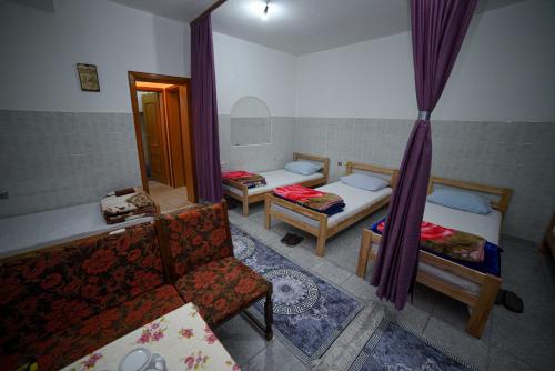a room with two beds and a chair and a mirror at Prenoćište KRAJINA in Velika Kladuša