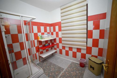 a bathroom with red and white tiles and a shower at Prenoćište KRAJINA in Velika Kladuša
