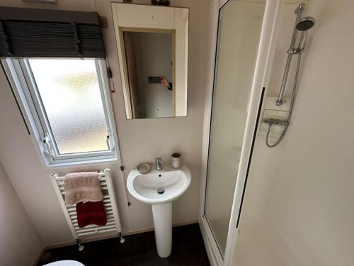 a small bathroom with a sink and a mirror at Elegance on Southview in Lincolnshire