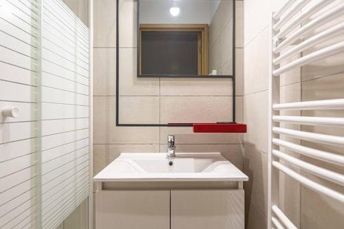 ein Badezimmer mit einem weißen Waschbecken und einem Spiegel in der Unterkunft Lavie Maison large comfy flat in Bordeaux