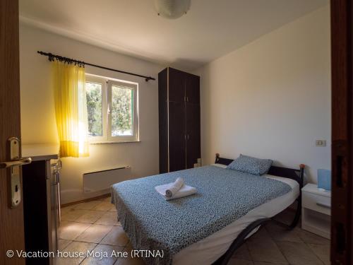 um quarto com uma cama com uma toalha branca em Moja Ane em Rtina