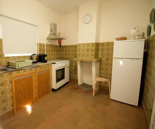 a kitchen with a white refrigerator and a stove at Casa da Avó Marquinhas in Carlão