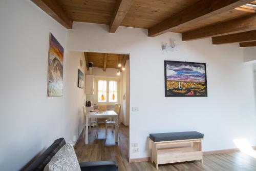 una sala de estar con paredes blancas y techos de madera. en Il Borgo appartamento Luca en Parma