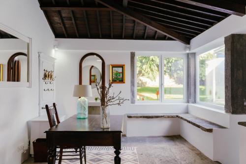 a dining room with a table and windows at Senhora do Carmo Charm House in Ponta Delgada