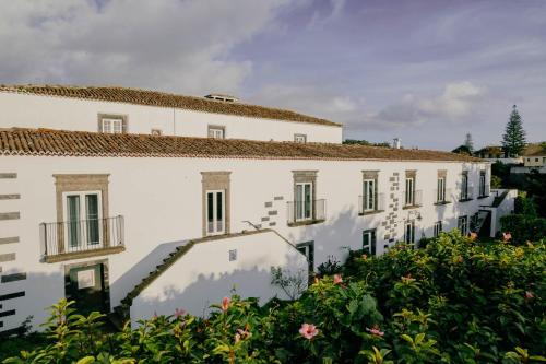 a white building with flowers in front of it at Senhora do Carmo Charm House in Ponta Delgada