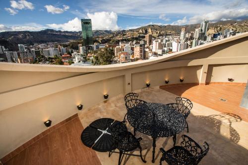 a table and chairs on a balcony with a view of a city at Hotel Boutique Rosario Sur in La Paz