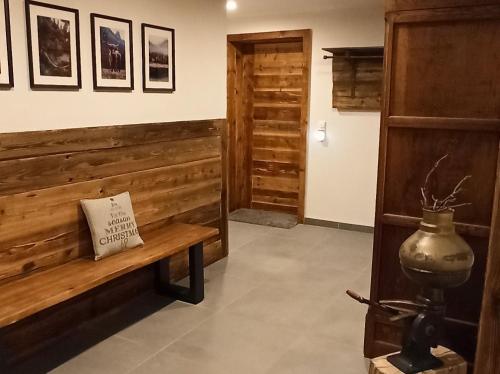 Cette chambre est dotée d'un mur en bois et d'un banc. dans l'établissement Bergfee Natur Appartements, à Nesselwängle