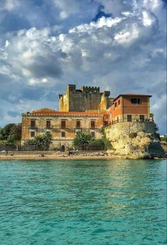 a castle sitting on top of a island in the water at Alessi Suites & Studio in Mazzarino