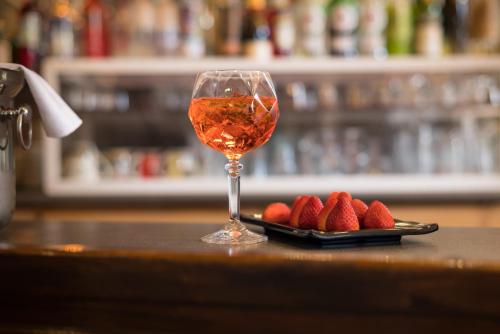 a glass of wine next to a plate of strawberries at Arahova Inn Hotel in Arachova