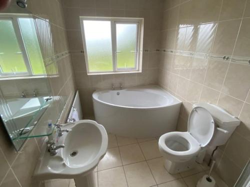 a bathroom with a tub and a toilet and a sink at Holywell cottage 