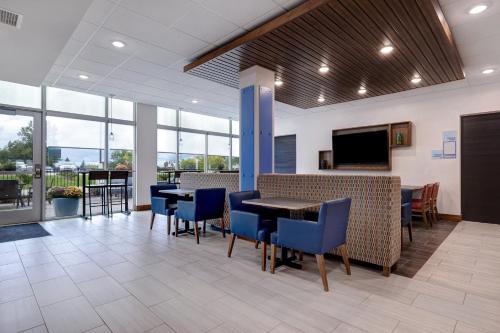 a dining room with tables and chairs and a flat screen tv at Holiday Inn Express & Suites - Ann Arbor - University South by IHG in Ann Arbor