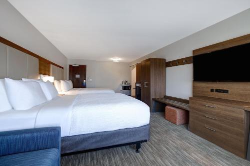 a hotel room with a large bed and a flat screen tv at Holiday Inn Express & Suites - Ann Arbor - University South by IHG in Ann Arbor