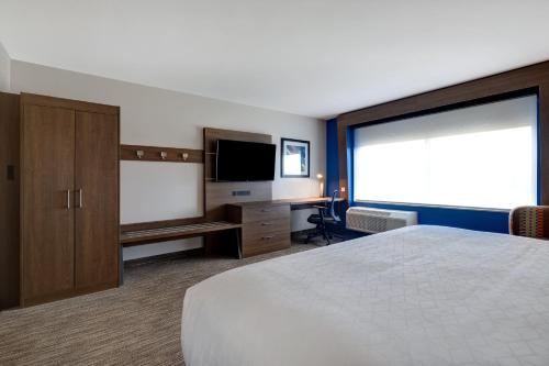 a hotel room with a bed and a flat screen tv at Holiday Inn Express & Suites - Ann Arbor - University South by IHG in Ann Arbor