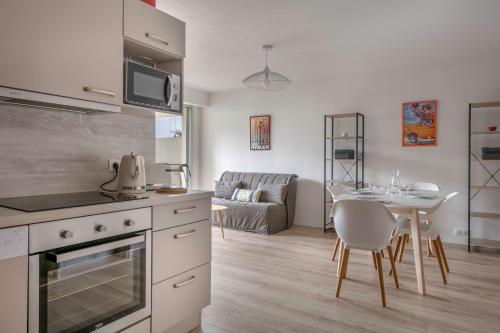 a kitchen and living room with a table and a couch at Coquet appartement a 300 m du port du Pouliguen in Le Pouliguen