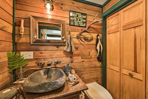 a bathroom with a stone sink and a mirror at Beautiful Embden Pond Cabin with Dock and Kayaks! in Embden