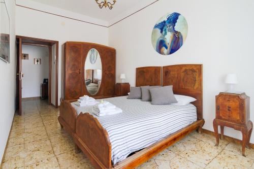 エルコラーノにあるCasa Biancaのベッドルーム1室(大型ベッド1台、木製ヘッドボード付)