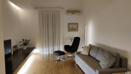 uma sala de estar com um sofá e uma cadeira em Casa di Roby em Bari