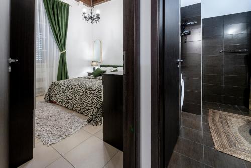 a bathroom with a bed and a shower with a glass door at Apartment Niko, Dubrovnik in Dubrovnik