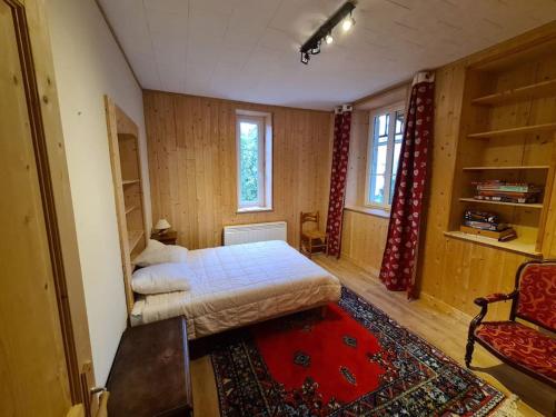 a bedroom with a bed and a chair in a room at Chalet chaleureux in Crillat