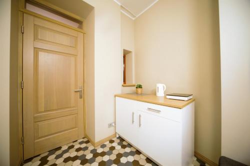 a small bathroom with a door and a checkerboard floor at Oldtown apartment / New house + elevator in Rīga