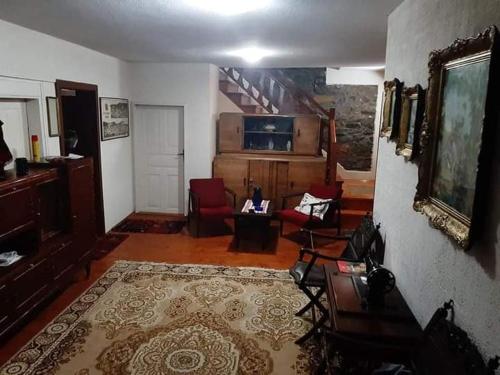 a living room with a couch and chairs and a staircase at **ETNO Vila** - KRUSEVO in Kruševo