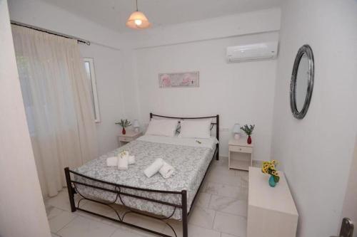 a bedroom with a bed with two candles on it at Filoxenia Apartments Corfu Rose in Alepou
