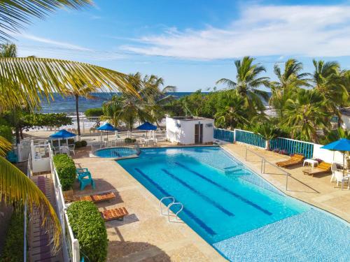 uma imagem de uma piscina num resort com o oceano em Condominio bahia blanca em Coveñas