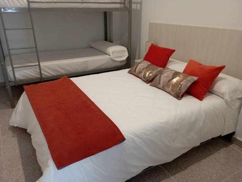 sypialnia z 2 łóżkami piętrowymi i czerwonymi poduszkami w obiekcie Casa Fernando y Maruja w mieście Pego