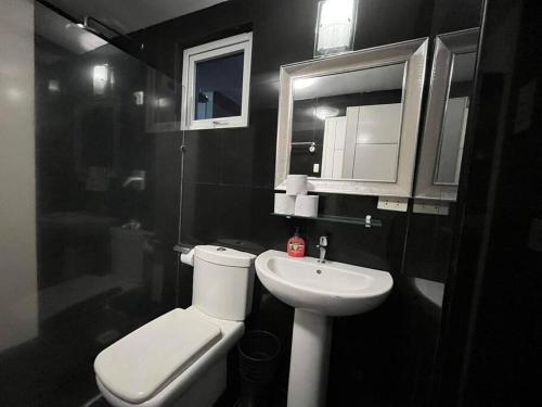 y baño con aseo blanco y lavamanos. en Kandi big 1 BR, king bed, free housekeeping, Wi-Fi, en Ángeles
