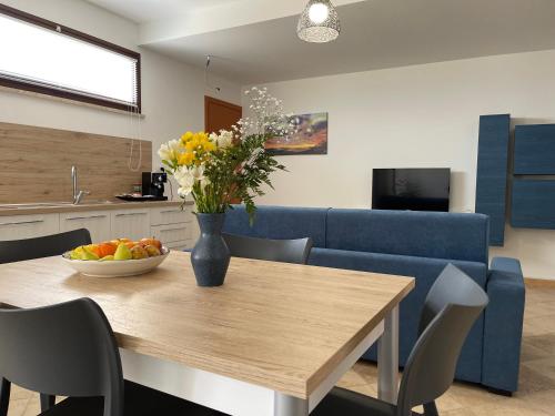 a living room with a table and a blue couch at GIOIA'S HOUSE in Custonaci